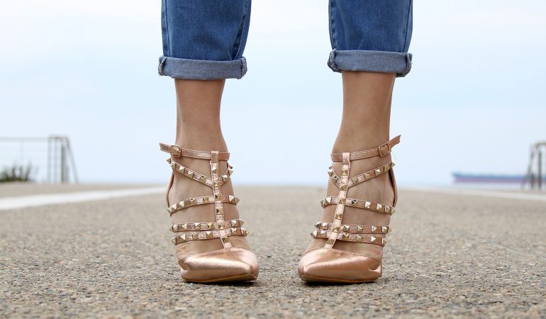 vue sur le bas des jambes d'une femme qui porte un jean et des chaussures à talons à clous